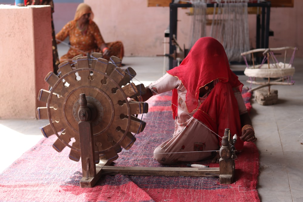 a person in a red robe and hat working on a machine