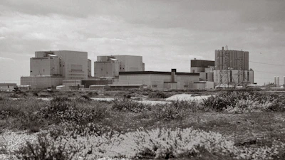 Wide shot of an industrial factory building clad with metal sheets in desert surroundings.