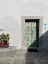 a green door on a stone building