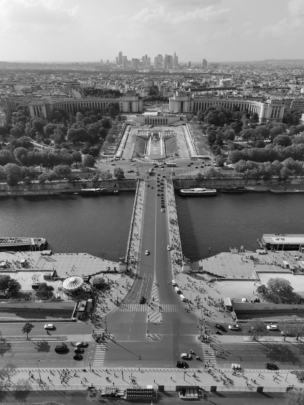 a bridge over a river with cars on it and a city in the background