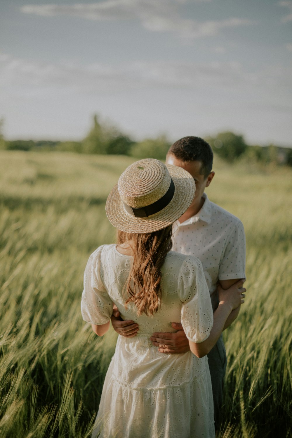a man and woman kissing in a field of grass