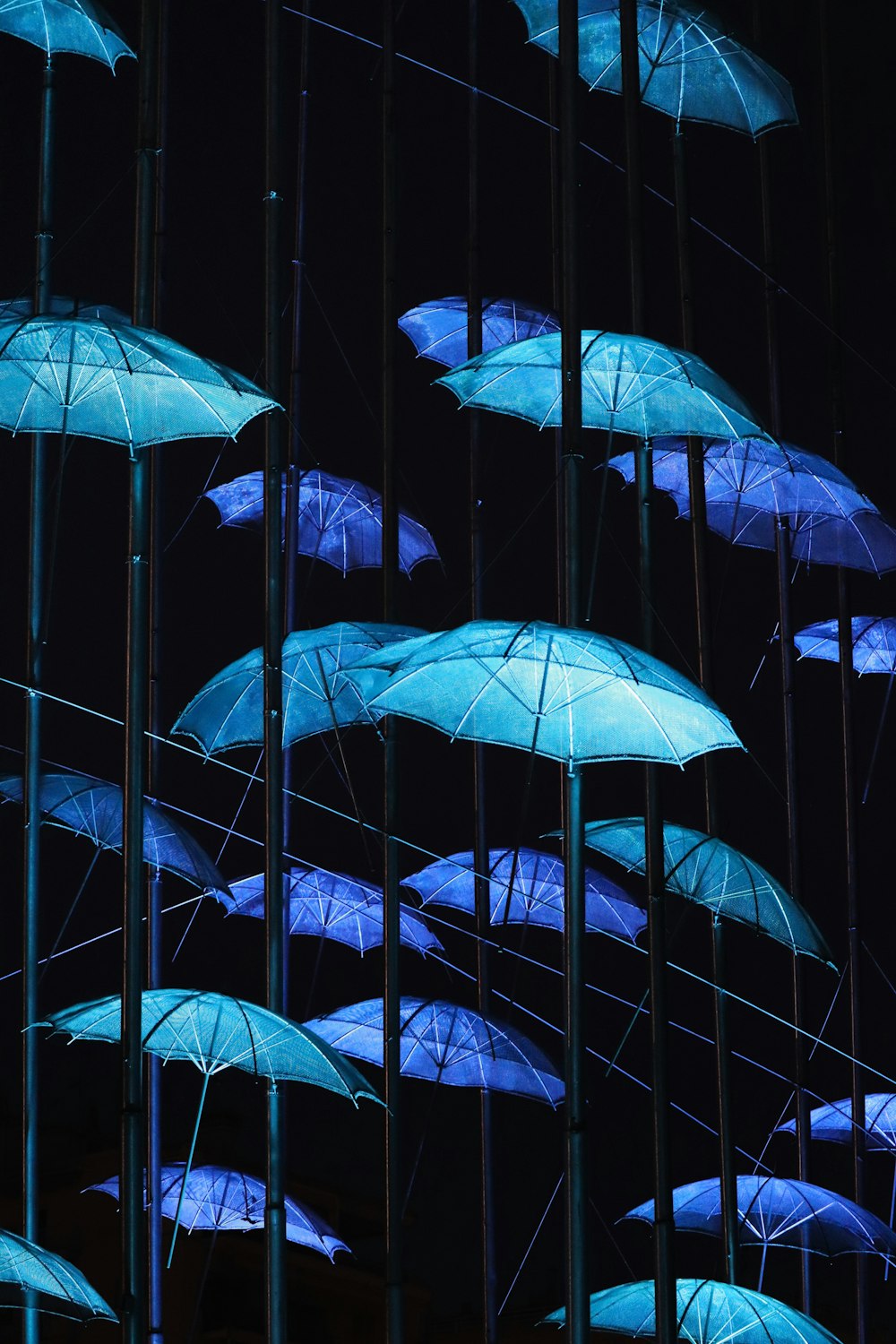 a group of umbrellas are from a ceiling