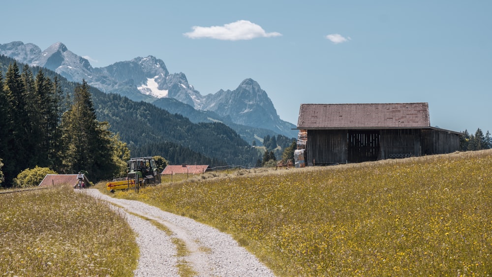 a dirt road leading to a barn