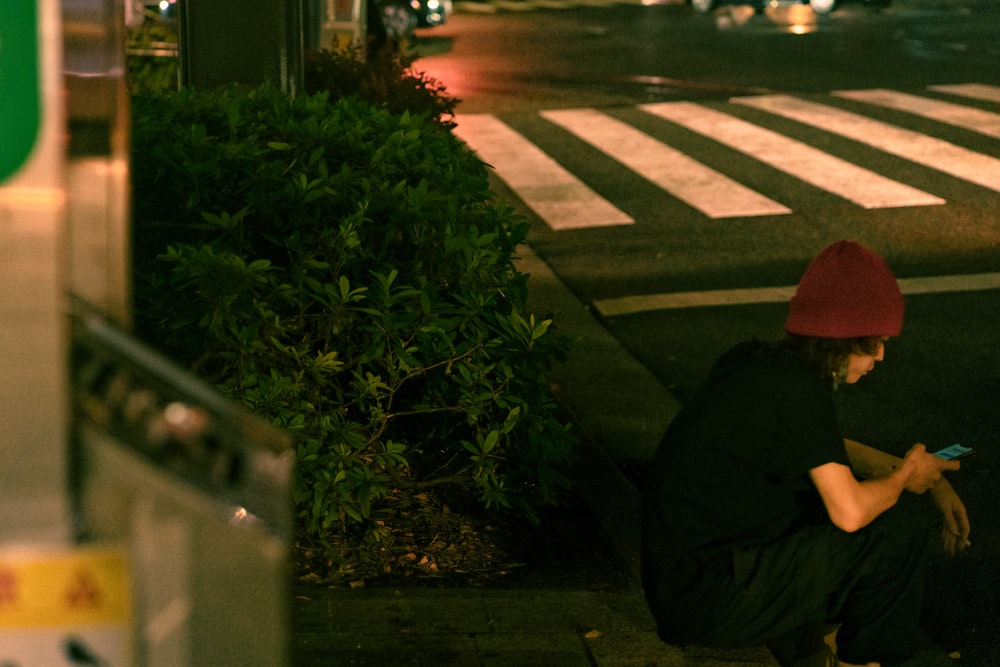 a man sitting on a sidewalk