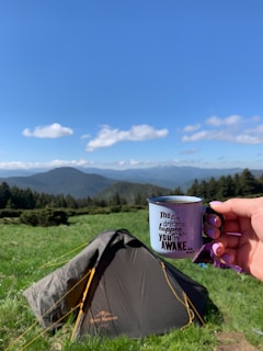 Close-up of a cozy mug featuring a mountain topographic map with an inspiring quote.