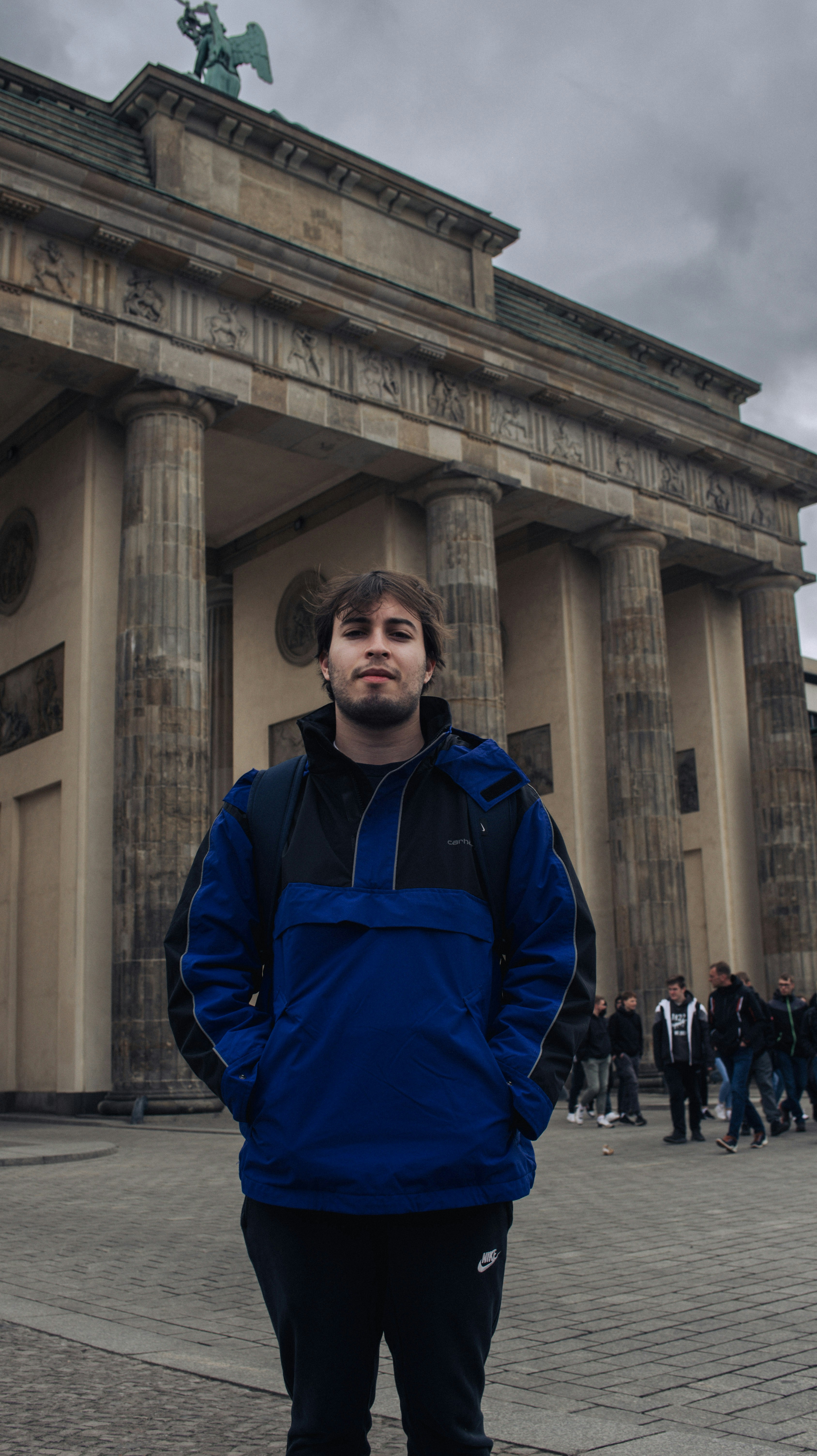 um homem em pé na frente de um edifício com colunas