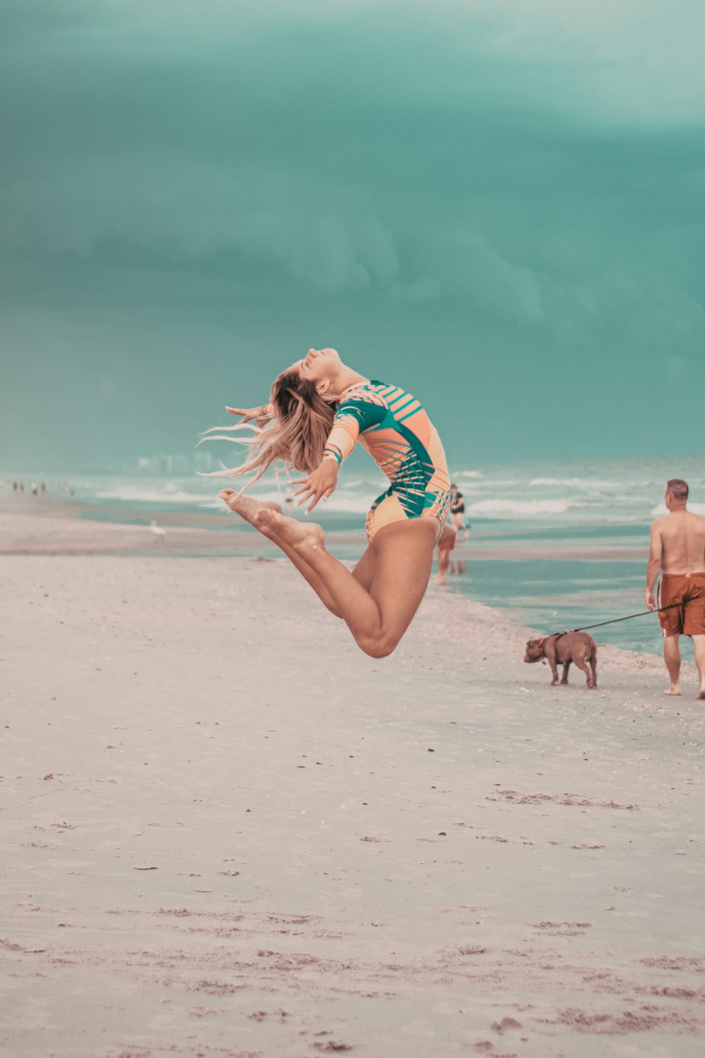 a woman jumping on a beach