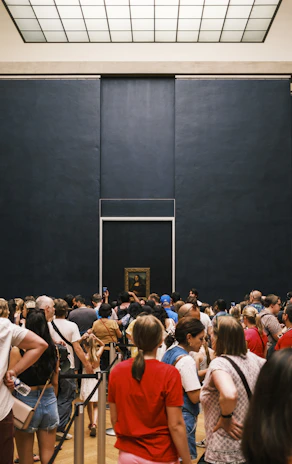 A panoramic shot of visitors admiring a large mural painted on a gallery wall.