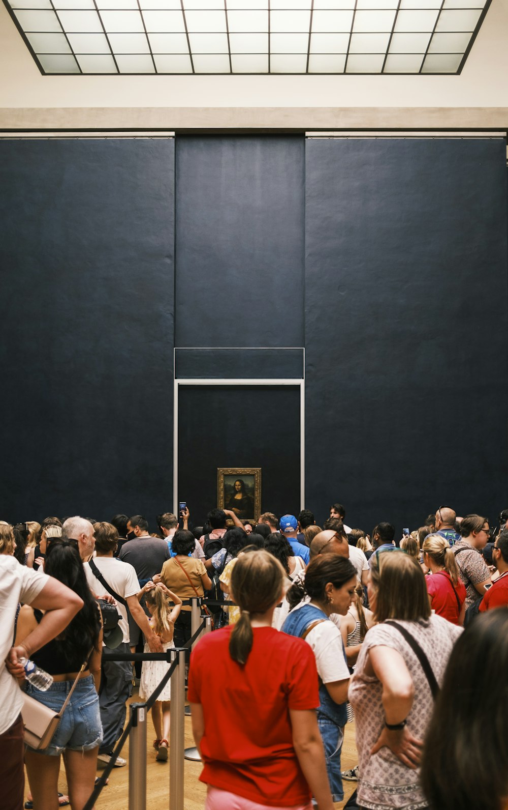 a group of people standing in front of a black wall