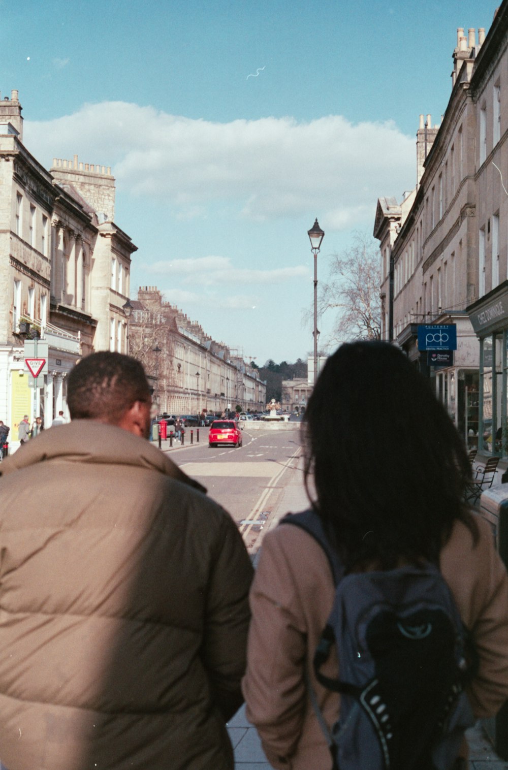 a couple of people looking at a street with buildings on either side
