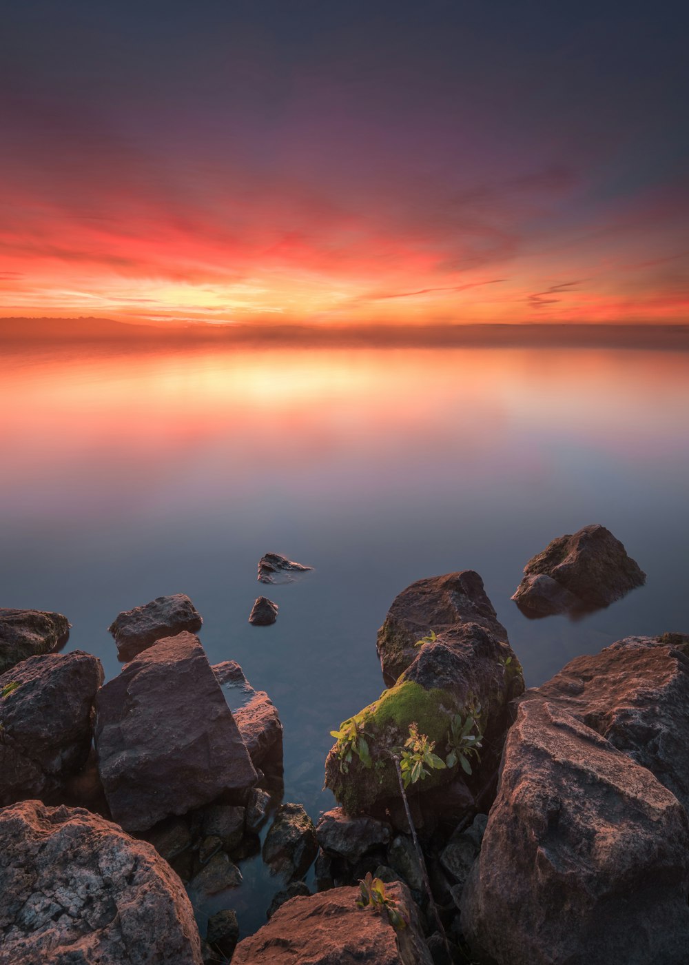 a group of rocks with a sunset in the background