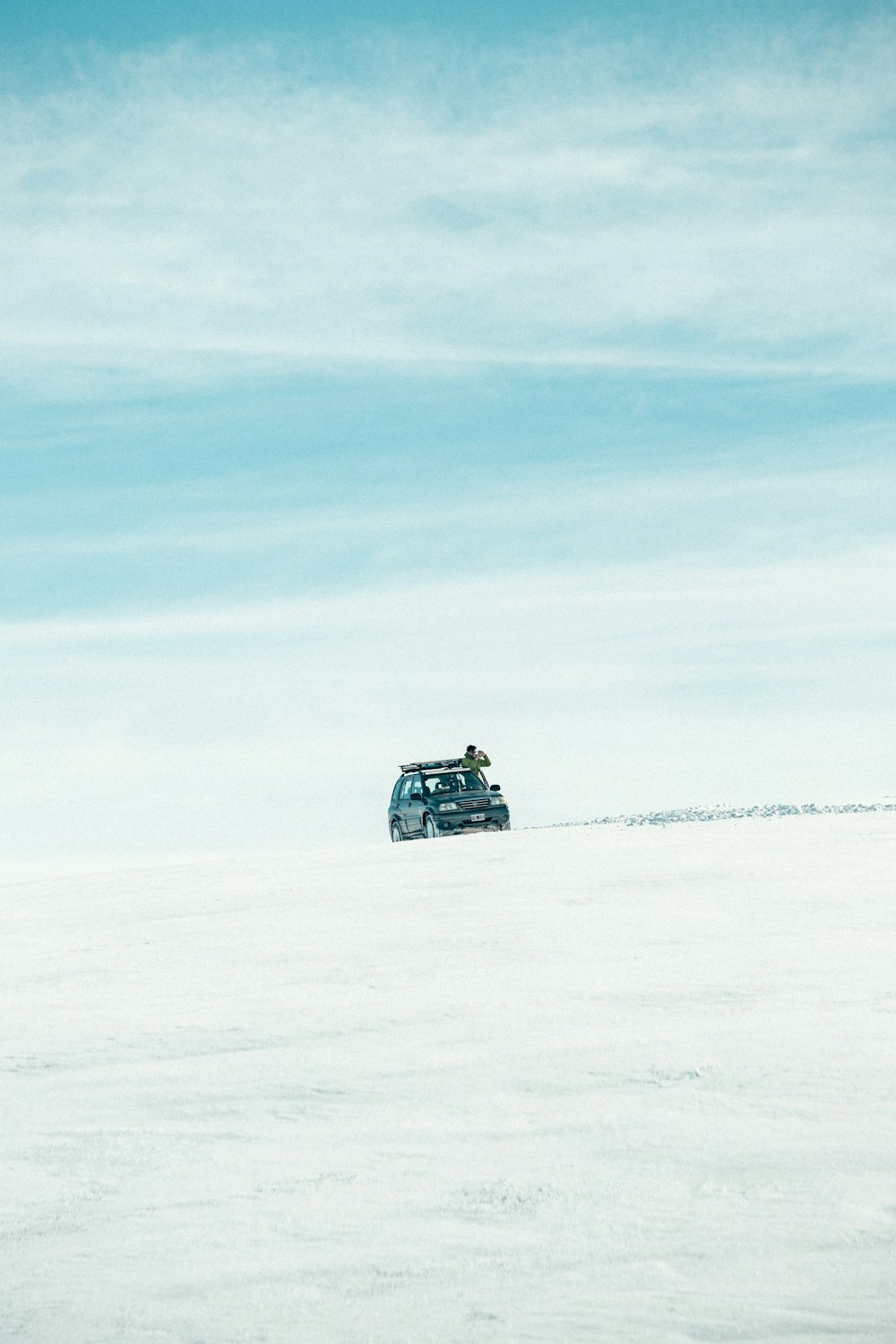a vehicle driving through a snowy area