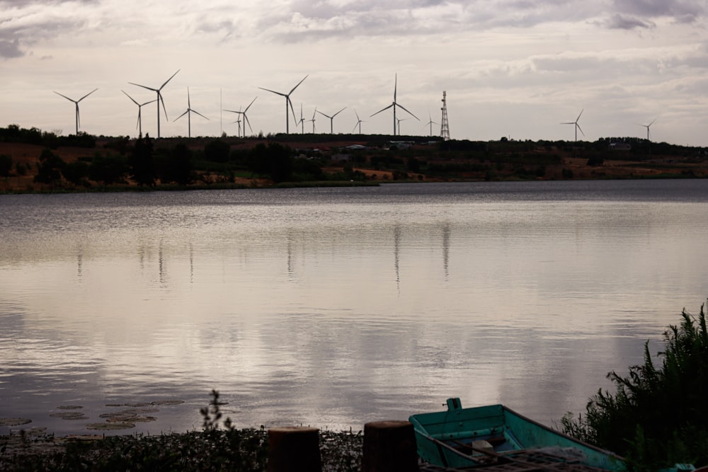 a body of water with windmills in the background