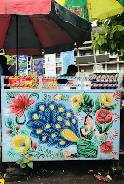 A vibrant outdoor market stall adorned with subtle feather decorations and aviara branded bird feed bags.