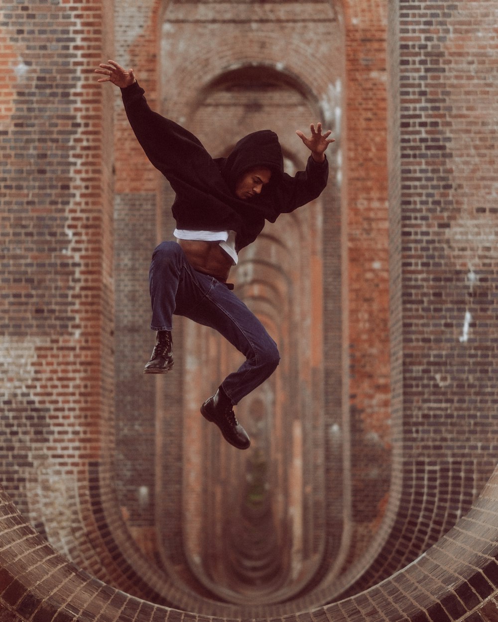 a man doing a trick on a skateboard on a brick building