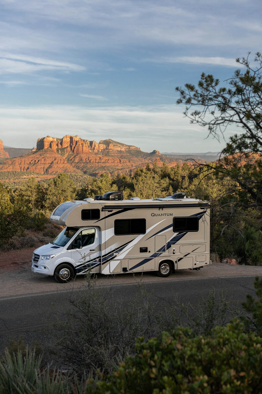 a white van parked on a road with trees and mountains in the background