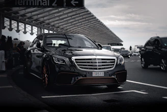 Black Mercedes-Benz S-Class waiting at an airport terminal