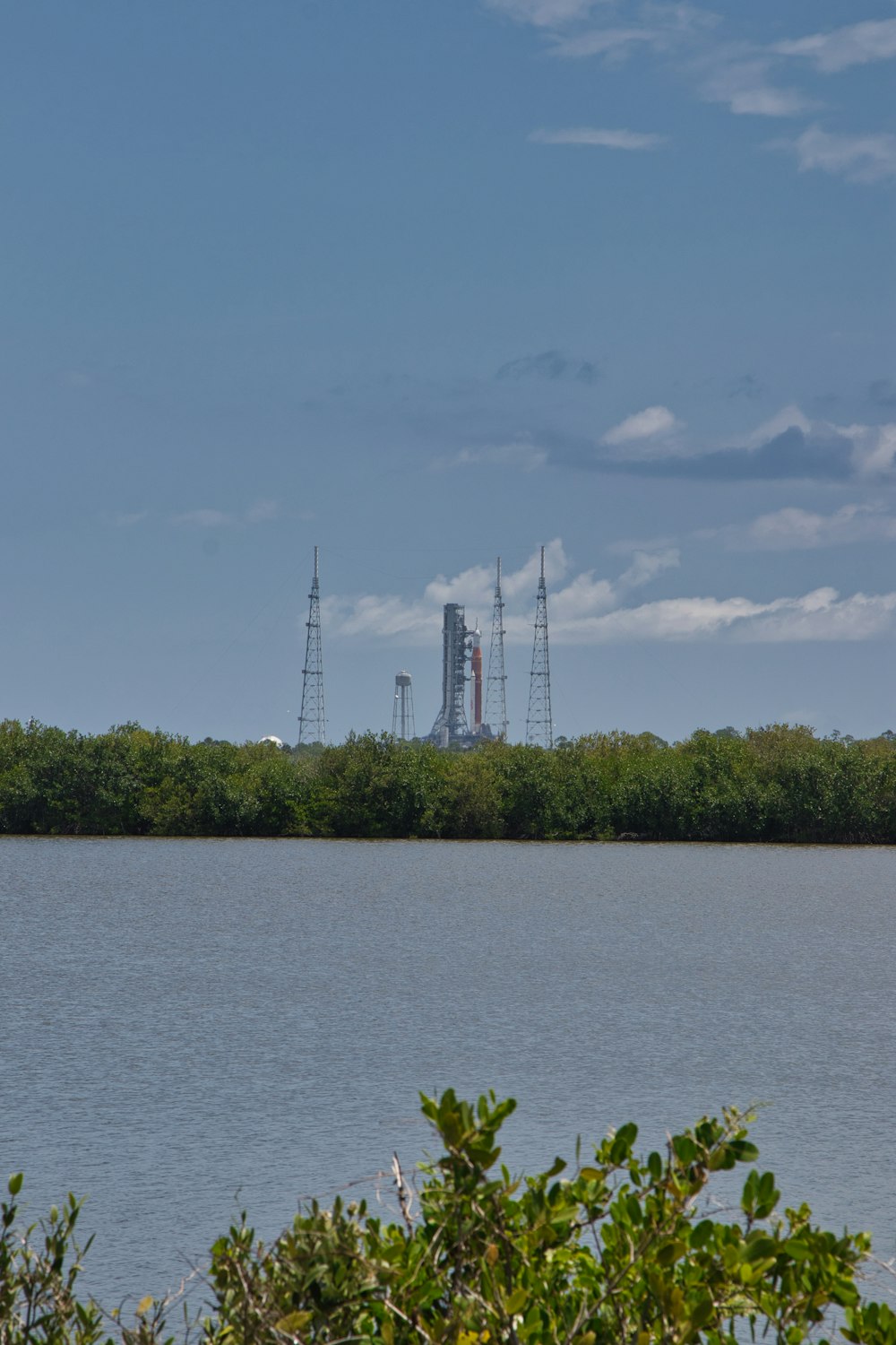 a body of water with trees and towers in the background