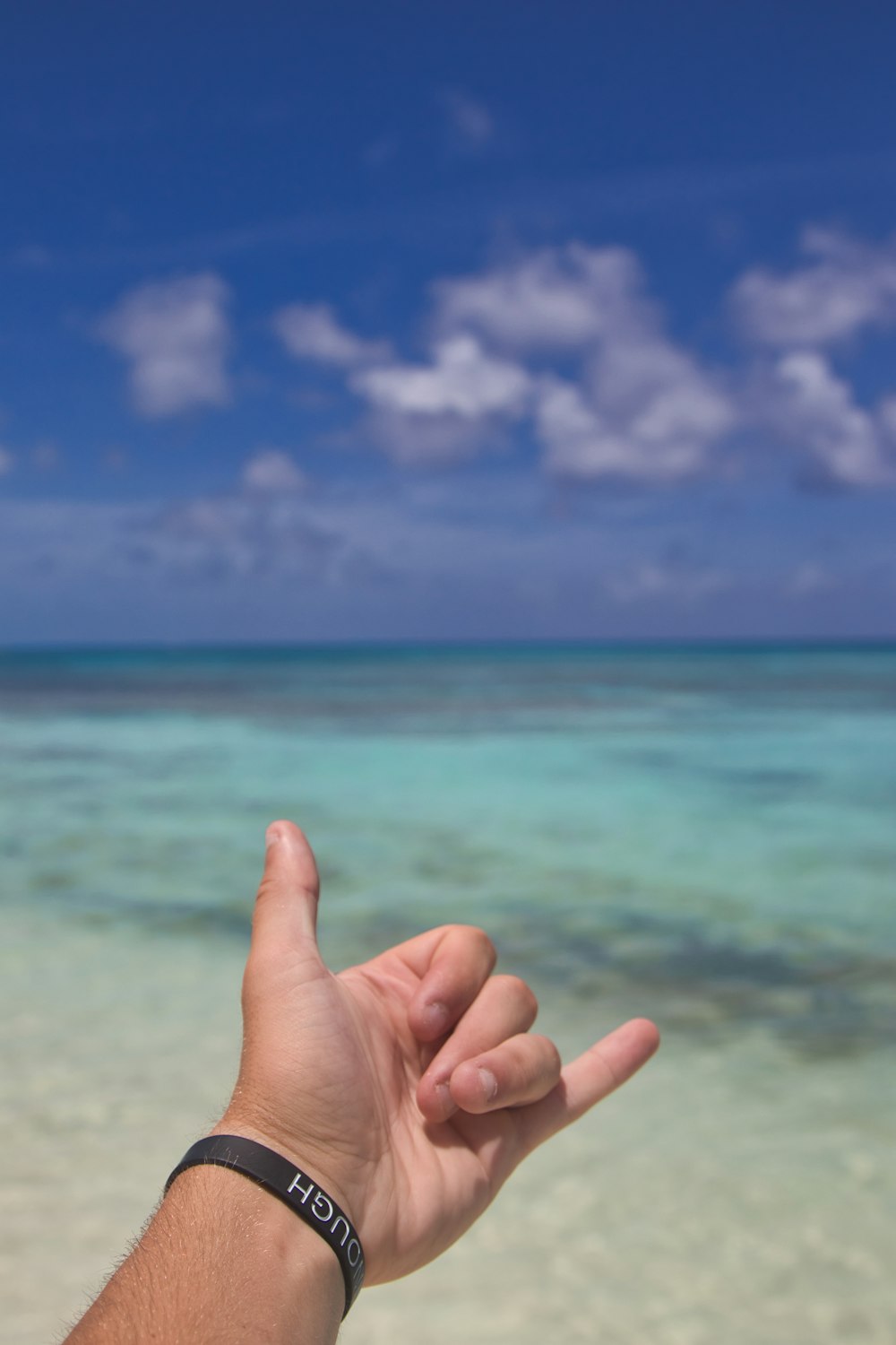 a hand with a watch on a beach