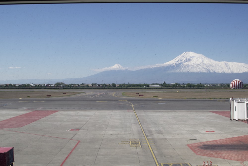 a large empty parking lot with a mountain in the background