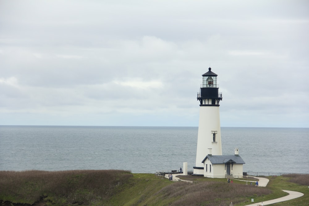 a lighthouse on a hill by the water with Yaquina Head Light in the background