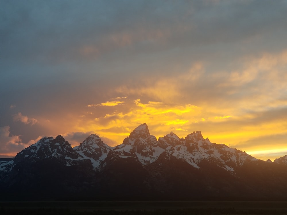 a snowy mountain with a cloudy sky