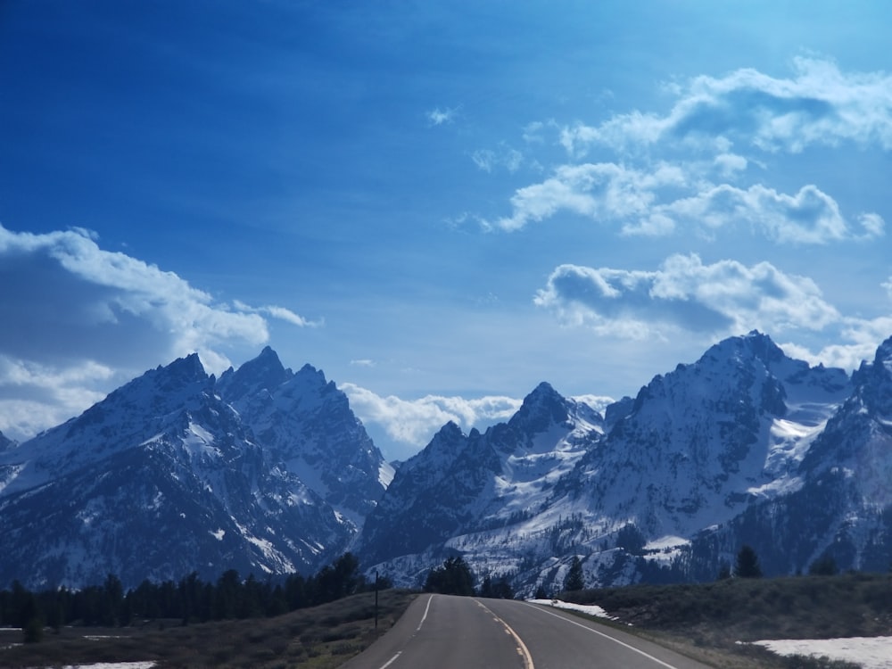 une route menant à une chaîne de montagnes