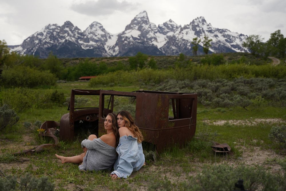 two women sitting in a field