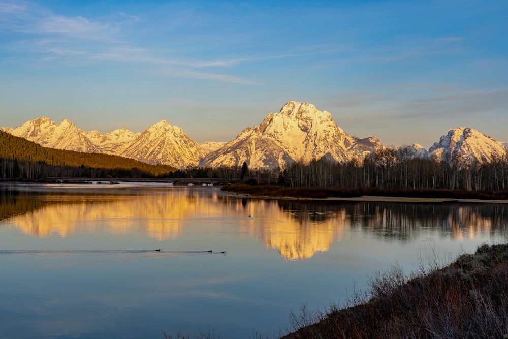 a lake with snowy mountains in the background