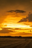 A peaceful sunset over a vast open field.