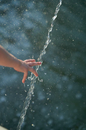 a hand holding a string of water