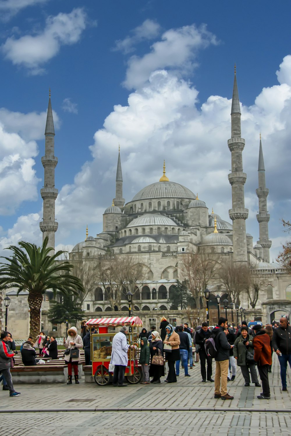 a group of people outside of Sultan Ahmed Mosque with towers