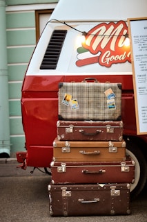 a stack of suitcases in front of a truck