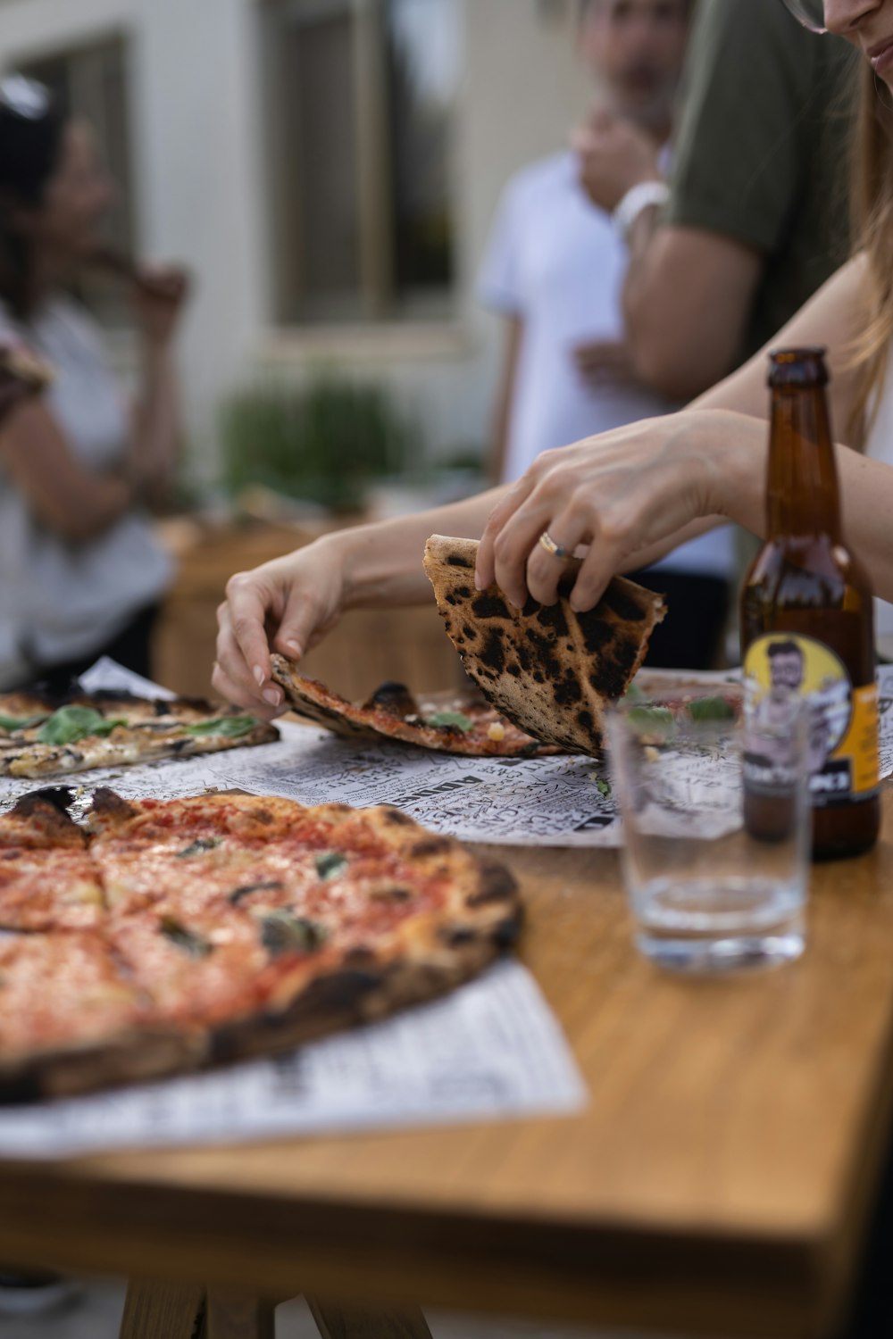 a person takes a slice of pizza