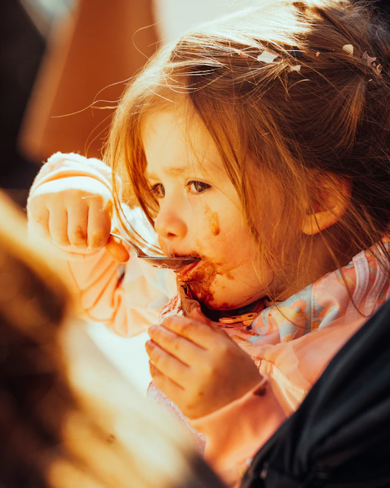 Close-up of a smiling baby enjoying a spoonful of nutritious homemade puree.