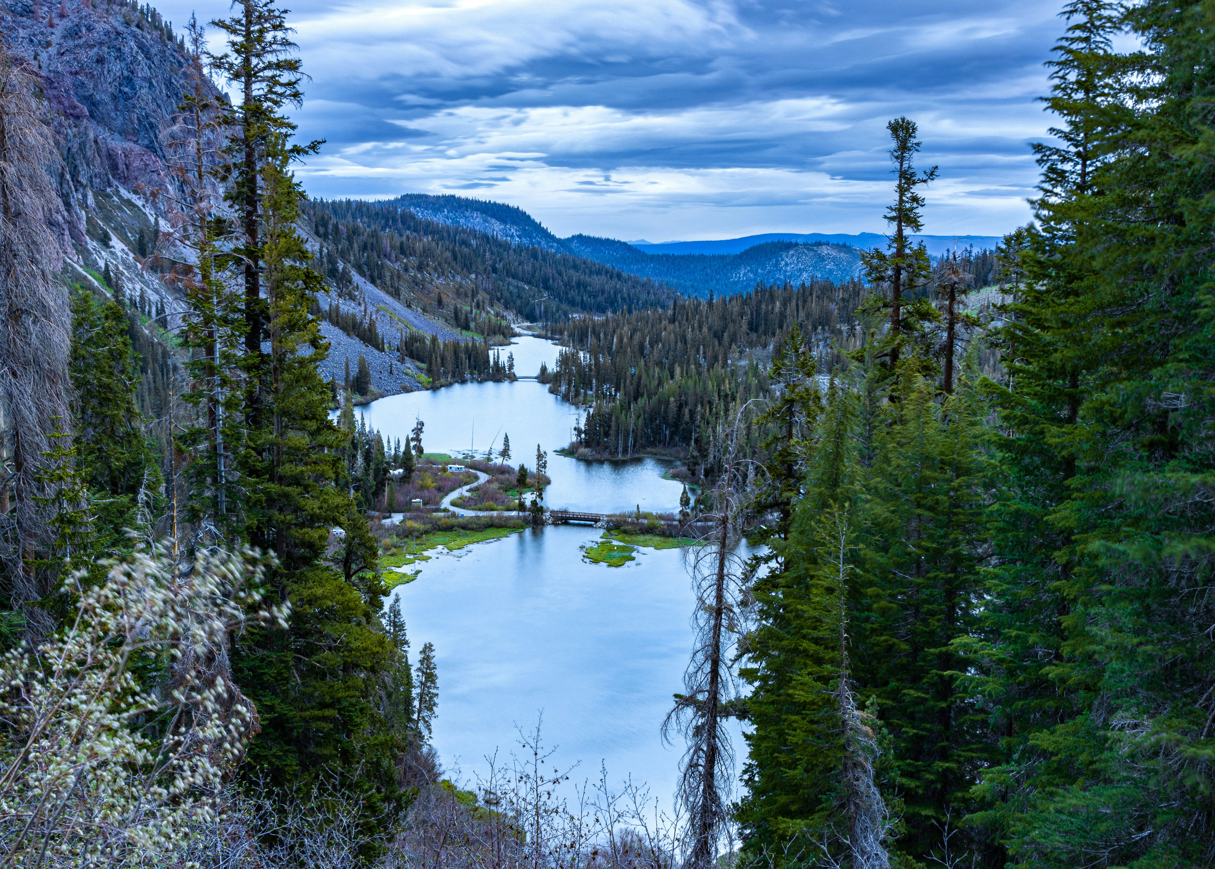 a river surrounded by trees and mountains