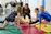 A teen gymnast confidently leading a group warm-up in a bright gym.