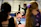 Focused teenage girl practicing acrobatics on a trampoline with coach support