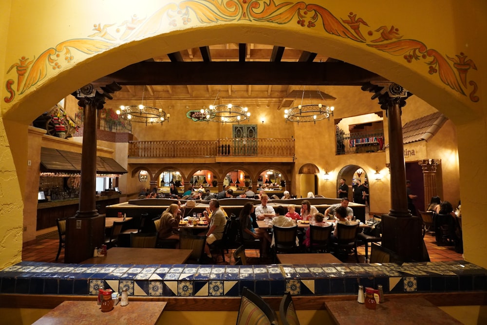 a group of people sitting at a table in a large room