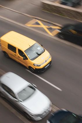 a yellow car and a white car on a road