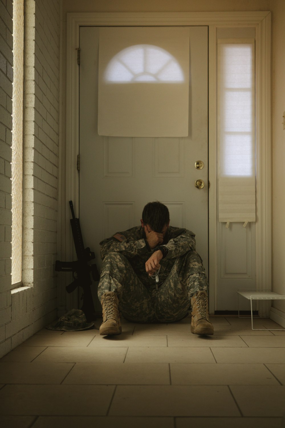 Una persona camuflada arrodillada frente a una puerta