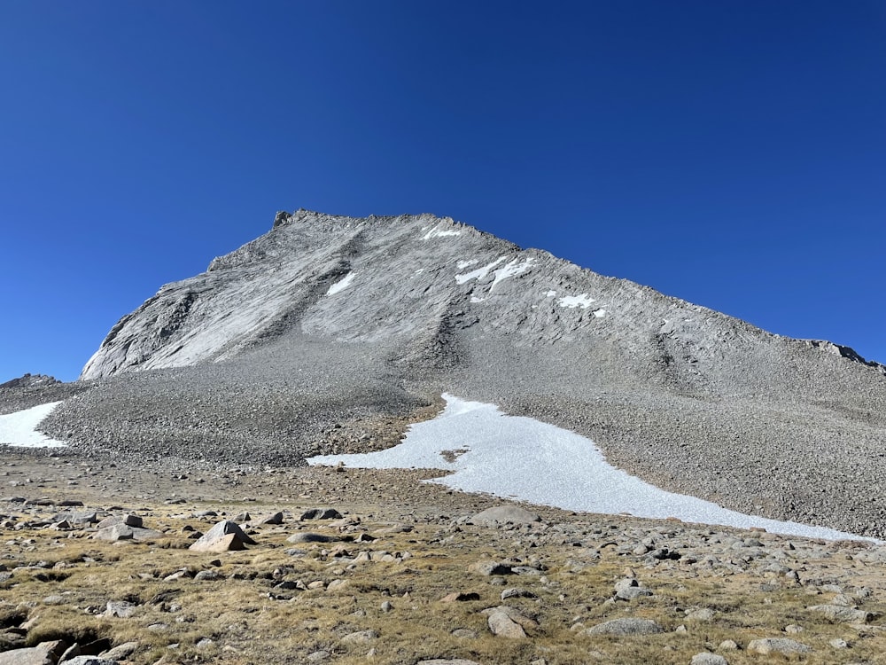 a snowy mountain with a stream running through it