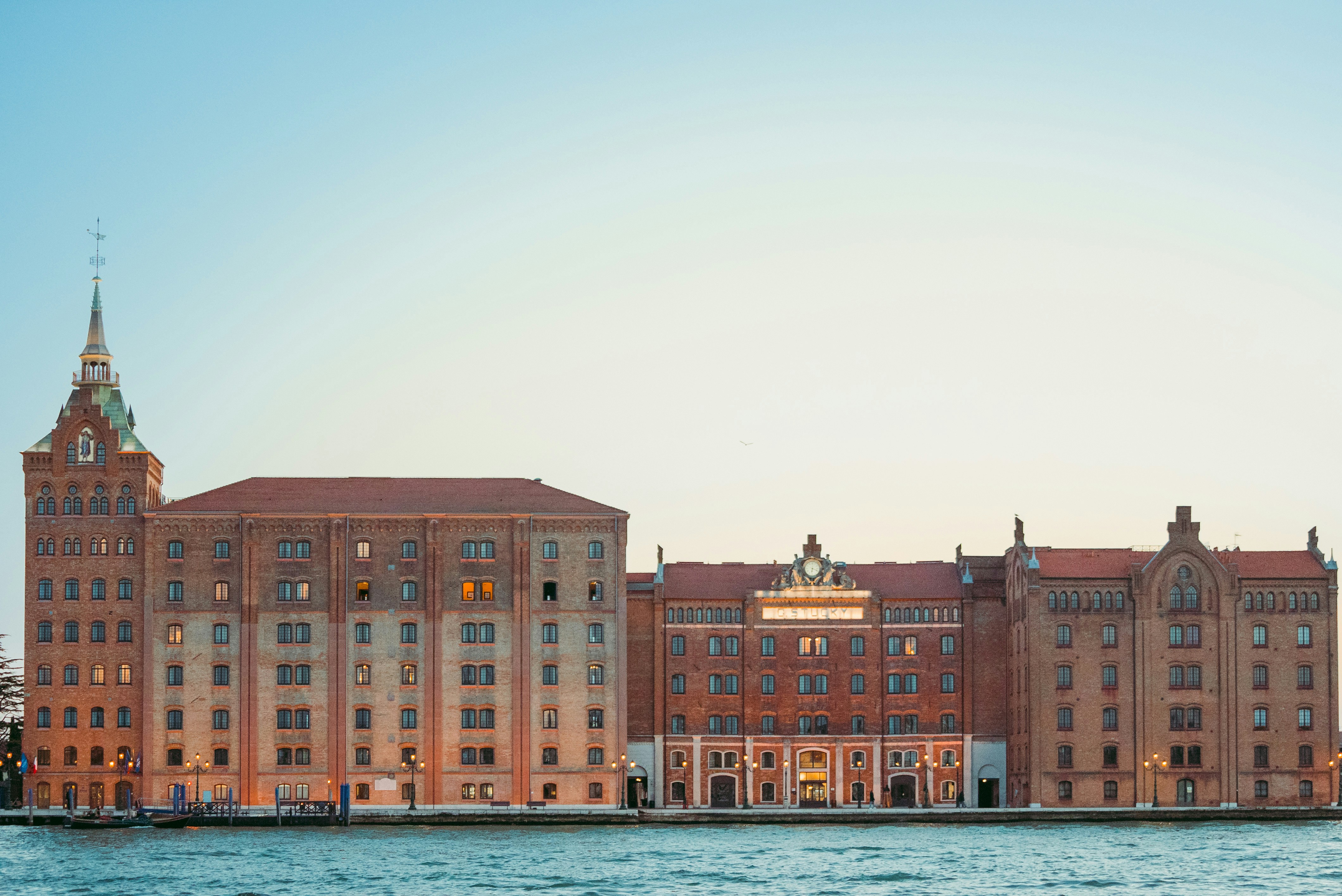 a group of buildings next to a body of water, Venice - Molino Stucky Hotel Hilton - San Giorgio Tower