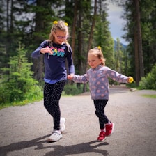 a person and a girl running on a road