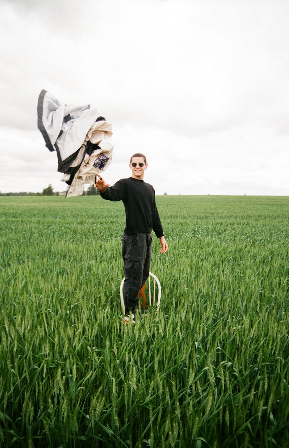 a man holding a kite in a grassy field