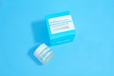 Different sized jars of Dermalume creams lined up on a dark gray surface
