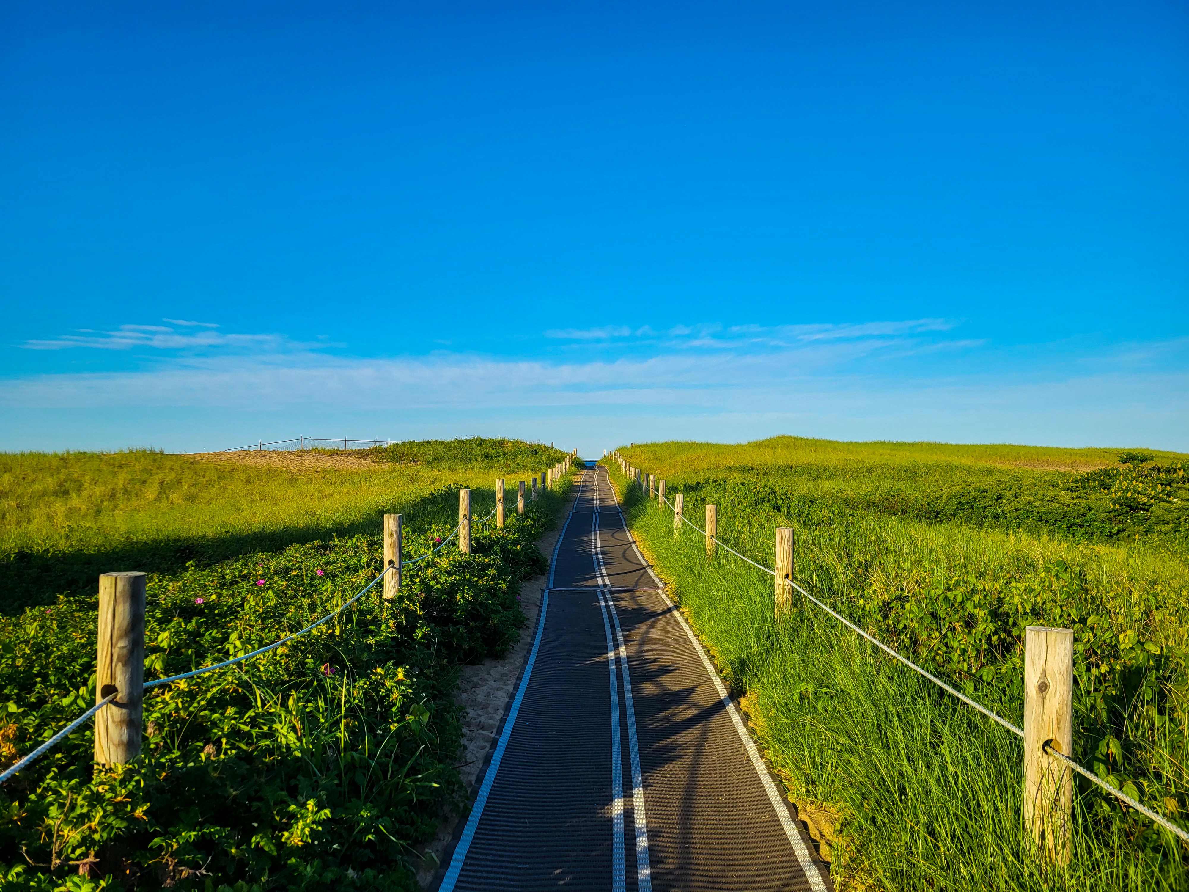 a long straight road with grass on either side of it