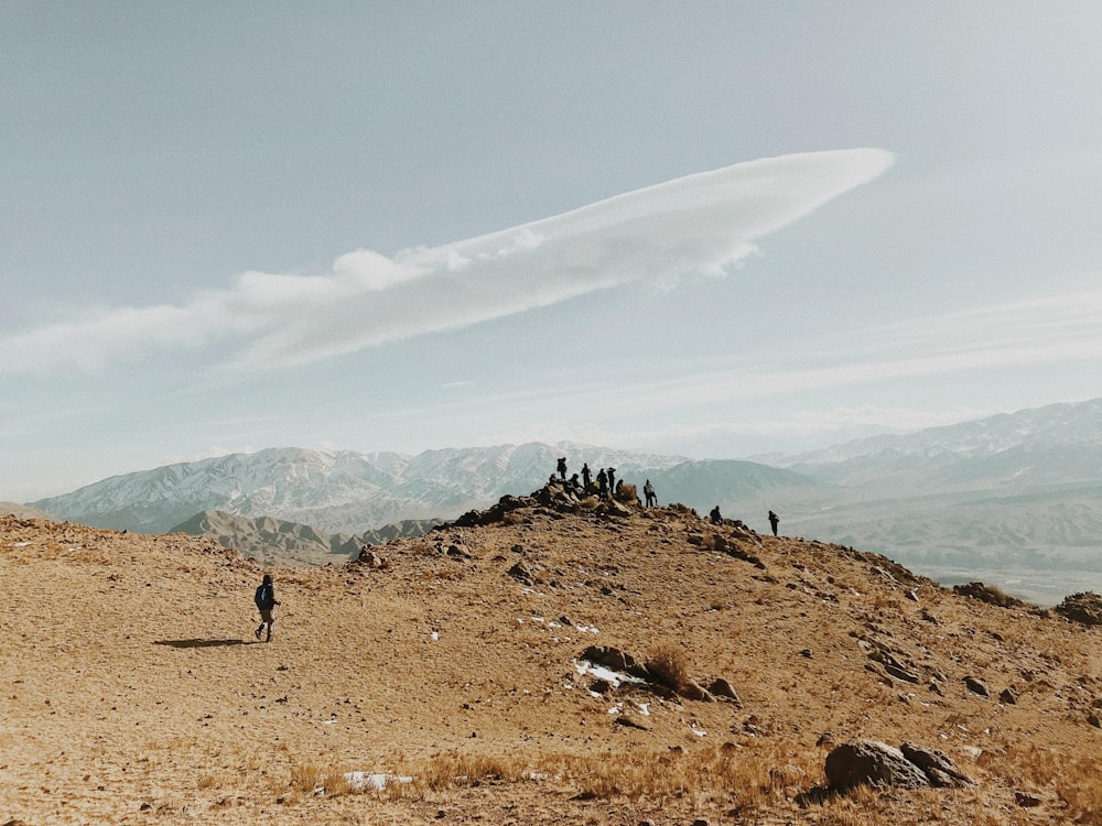 a group of people walking on a rocky hill