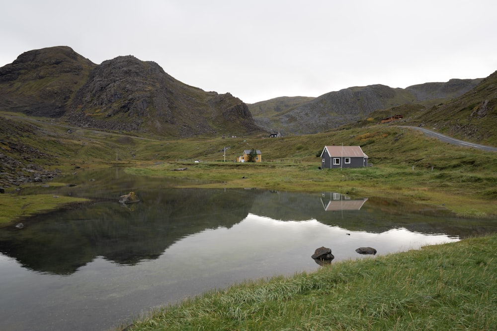 a small house on a hill by a lake