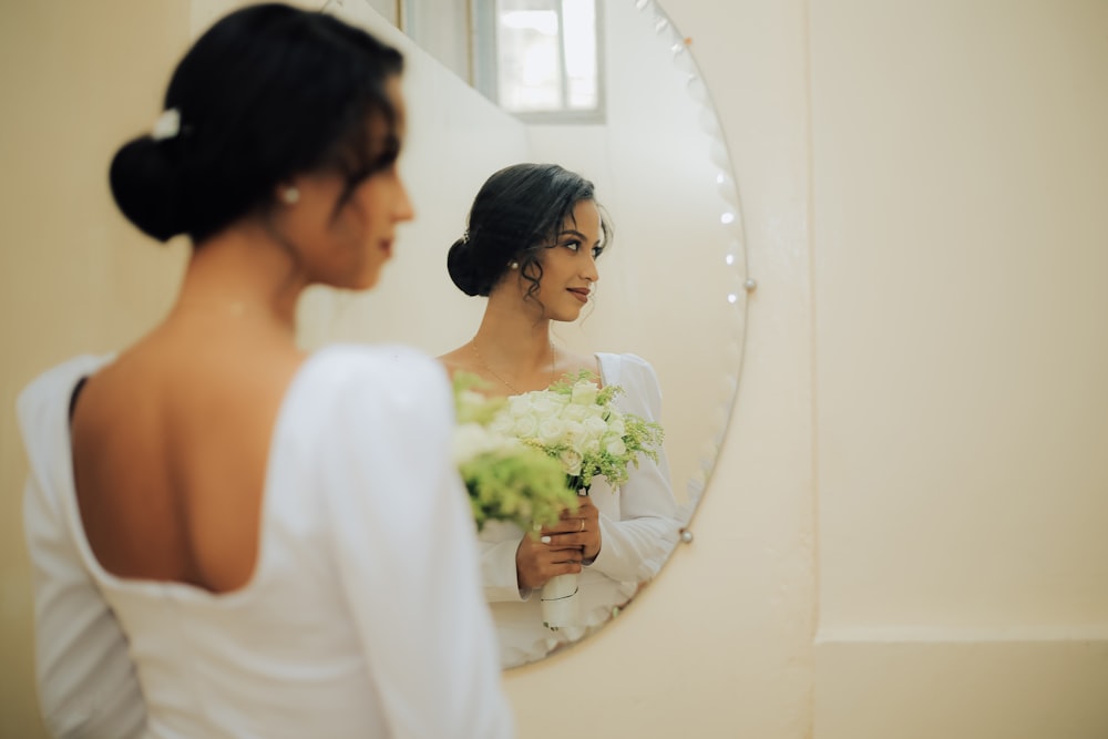 une personne debout devant un miroir posant pour la caméra